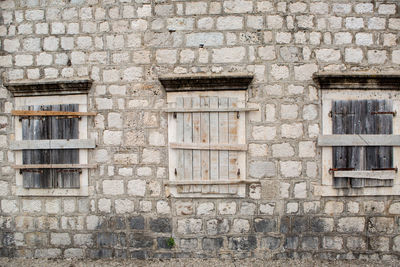 Boarded-up windows in an old stone building in montenegro