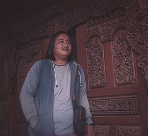 Portrait of smiling woman standing against building