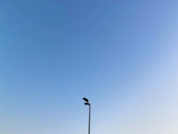 Low angle view of street light against blue sky