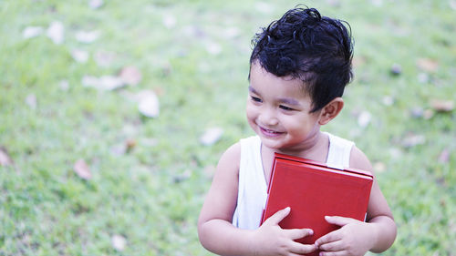 Smiling boy holding box in park