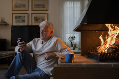 Midsection of man sitting on sofa at home