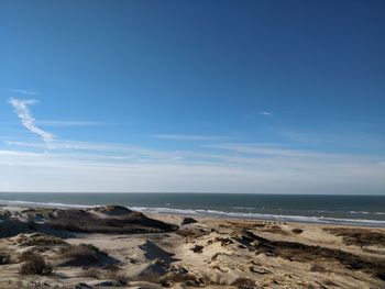 Scenic view of beach and sea against blue sky