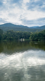 Scenic view of lake by mountains against sky