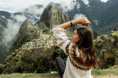 Rear view of woman standing against mountain