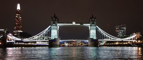 View of bridge over river at night