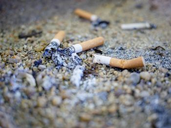 Close-up of cigarette smoking on ground