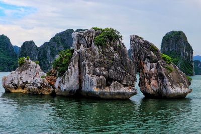 Rock formations in sea against sky