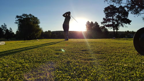 People on grassy field at sunset