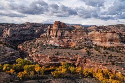 Rock formations on landscape against cloudy sky