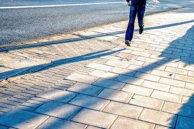 Low section of man walking on street