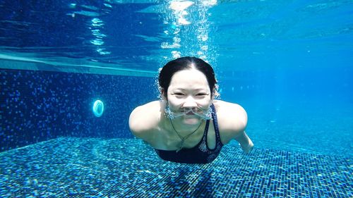 Portrait of young woman swimming in pool