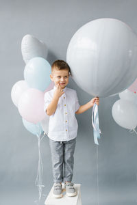 Gender reveal party. a four-year-old child holds a balloon in his hands to find out the gender 