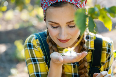  young woman smelling flower in park