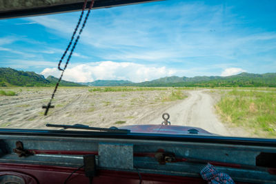 Car moving on road seen through windshield