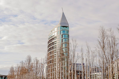 Low angle view of modern building against cloudy sky