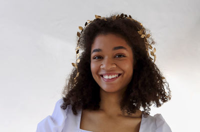 Portrait of smiling young woman against white background