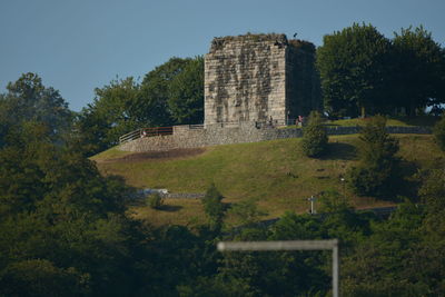Built structure by trees against sky