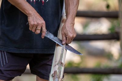 Midsection of man working on metal