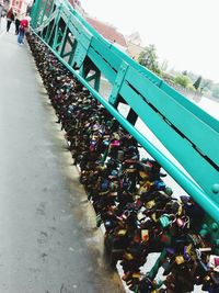 Low angle view of padlocks hanging on footbridge