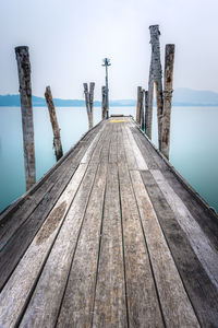 Wooden pier over sea against clear sky