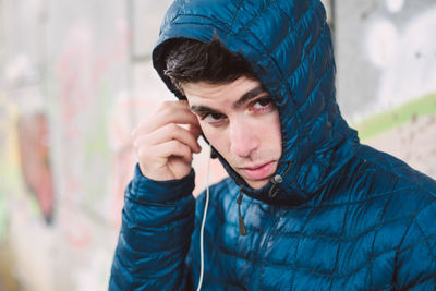 Portrait of young man holding hat