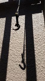 High angle view of old iron hook and shadow
