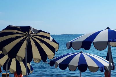 Umbrellas on beach against clear sky