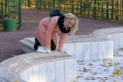 Woman sitting on railing