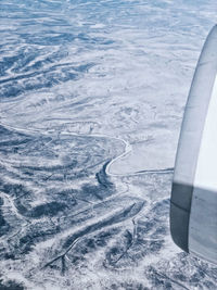 High angle view of airplane flying over snow