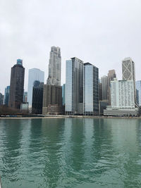 Modern buildings by swimming pool in city against sky
