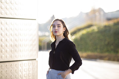 Confident businesswoman standing with hands in pockets outdoors