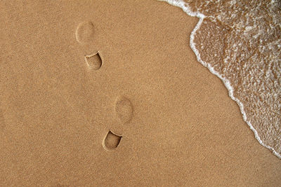 High angle view of footprints on sand at beach