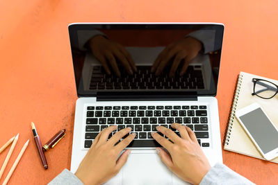 Midsection of man using laptop on table