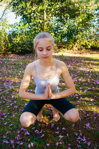 Beautiful young woman practicing yoga at park