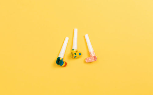 High angle view of colored pencils against yellow background