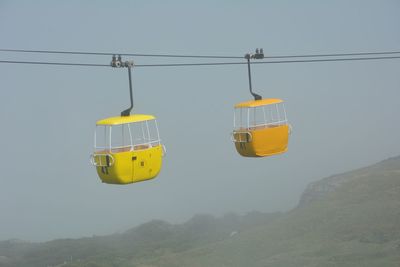 Overhead cable cars against clear sky