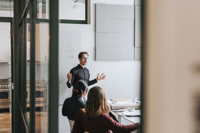 Businessman gesturing during meeting with colleagues in board room at office