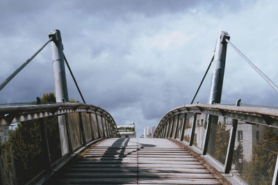 Low angle view of bridge against cloudy sky