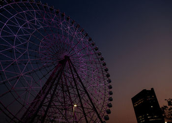 Low angle view of illuminated ferris wheel against sky at night