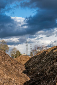 Electricity pylon on land against sky