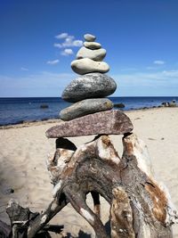 Stack of pebbles on beach against sky