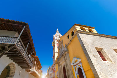 Low angle view of buildings against clear blue sky