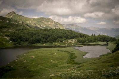 Scenic view of lake and mountains against sky