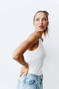 Portrait of young woman standing against white background