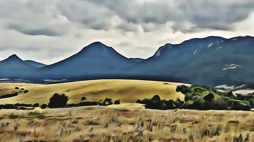 Scenic view of field and mountains against sky