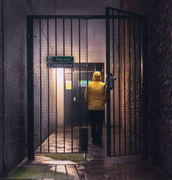 Rear view of man walking in corridor of building