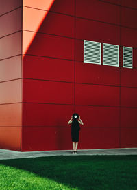 Full length rear view of woman standing against wall