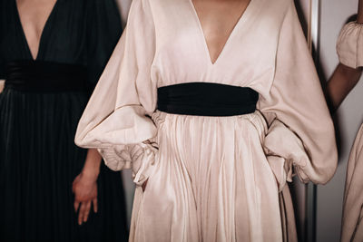 Fashion elegant feminine details of spring summer beige long dresses with black wide belts
