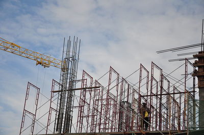 Low angle view of worker on construction site against sky