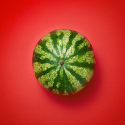 Directly above shot of lemon slice against red background